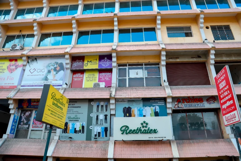 Exterior view of the multi-story commercial building housing the Reethatex Uniforms store in Trivandrum
